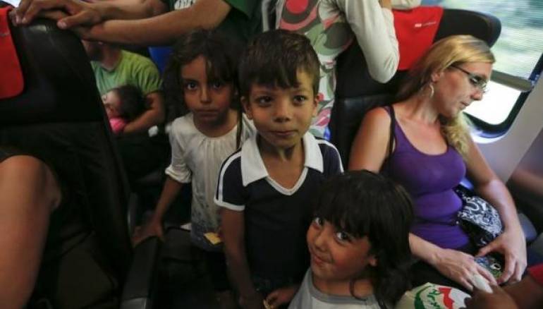 Children stand among seats in a train with migrants on board, en route from Budapest to Vienna, Austria, August 31, 2015. REUTERS/LASZLO BALOGH