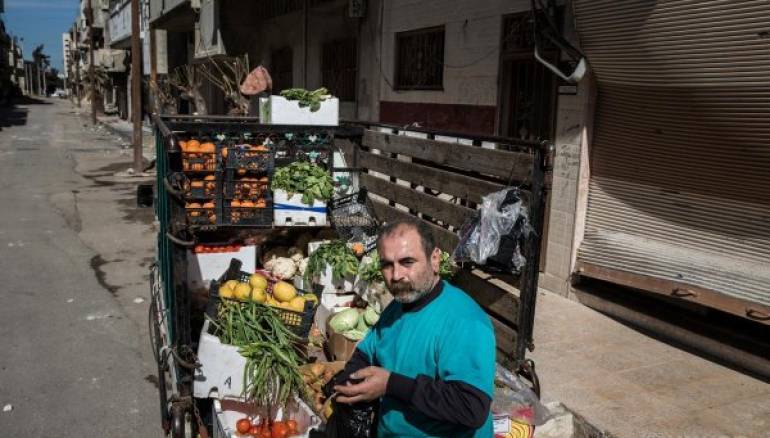 "We are dead here, just barely surviving." Yousef sells produce in Homs, Syria, after his family fled Aleppo in 2012